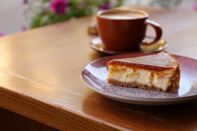 Photo of Plate with slice of cake on wooden table