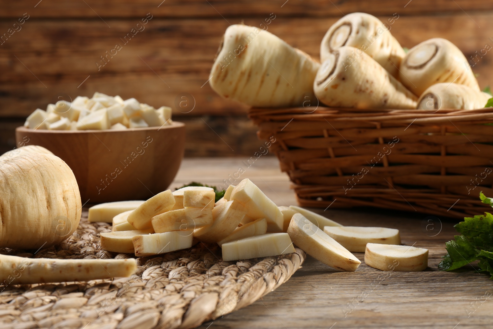 Photo of Whole and cut parsnips on wooden table