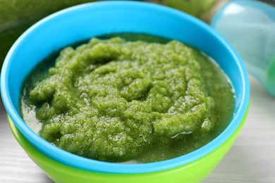 Photo of Healthy baby food. Bowl with tasty broccoli puree on white table, closeup