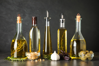 Composition with different sorts of cooking oil on grey table