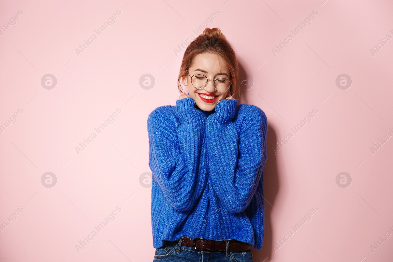 Photo of Beautiful young woman in warm sweater on color background