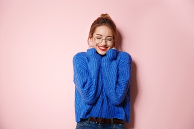 Photo of Beautiful young woman in warm sweater on color background