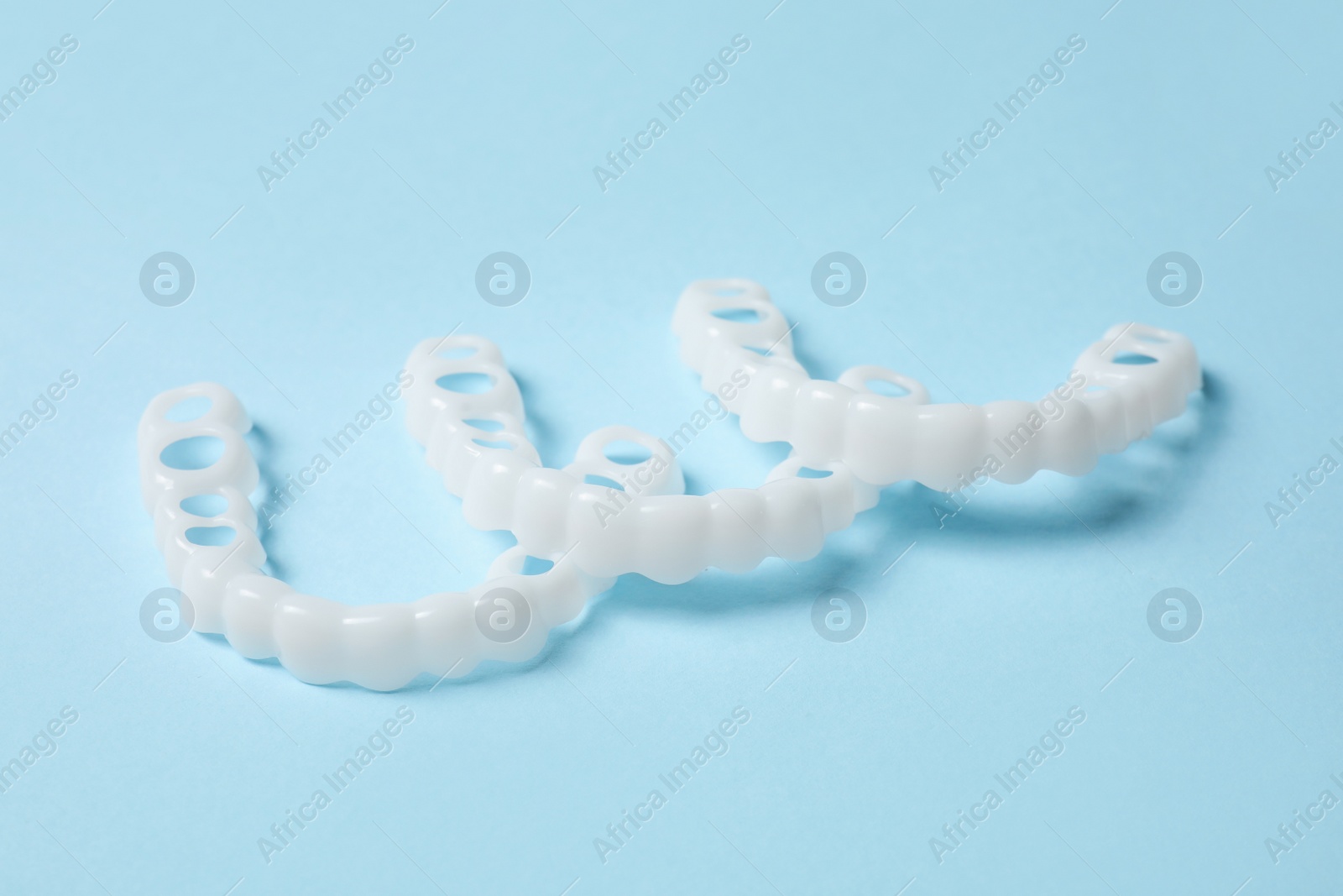 Photo of Dental mouth guards on light blue background. Bite correction