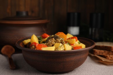 Photo of Tasty cooked dish with potatoes in earthenware on table
