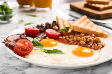 Tasty breakfast with fried eggs on white marble table, closeup