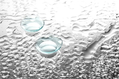 Contact lenses on wet glass background