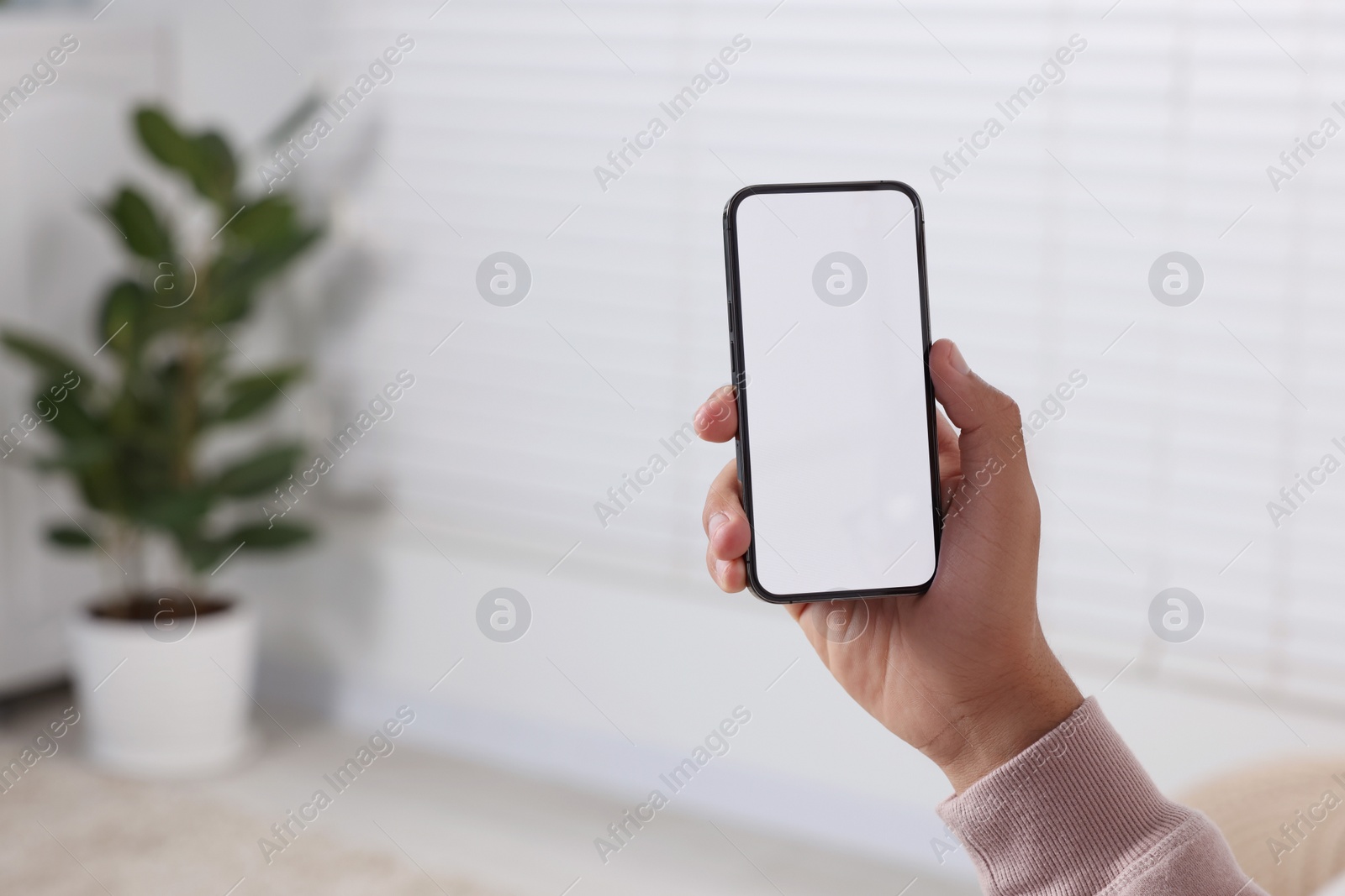 Photo of Man using modern mobile phone indoors, closeup. Space for text