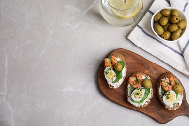 Delicious bruschettas with shrimps on grey table, flat lay. Space for text