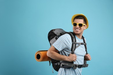 Photo of Male tourist with travel backpack on turquoise background, space for text