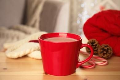 Photo of Cup of hot cocoa on wooden table indoors. Winter drink