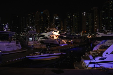 DUBAI, UNITED ARAB EMIRATES - NOVEMBER 03, 2018: Pier with luxury yachts at night