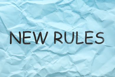 Text NEW RULES on sheet of color crumpled paper 