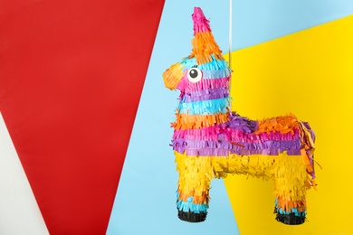 llama shaped pinata hanging on color background. Space for text