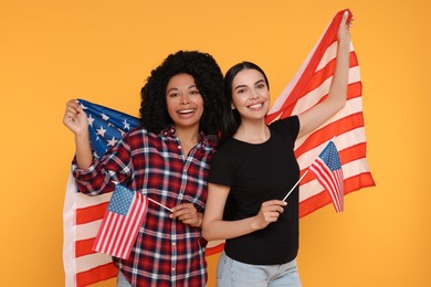Photo of 4th of July - Independence Day of USA. Happy women with American flags on yellow background