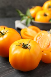 Photo of Fresh ripe yellow tomatoes on black board, closeup