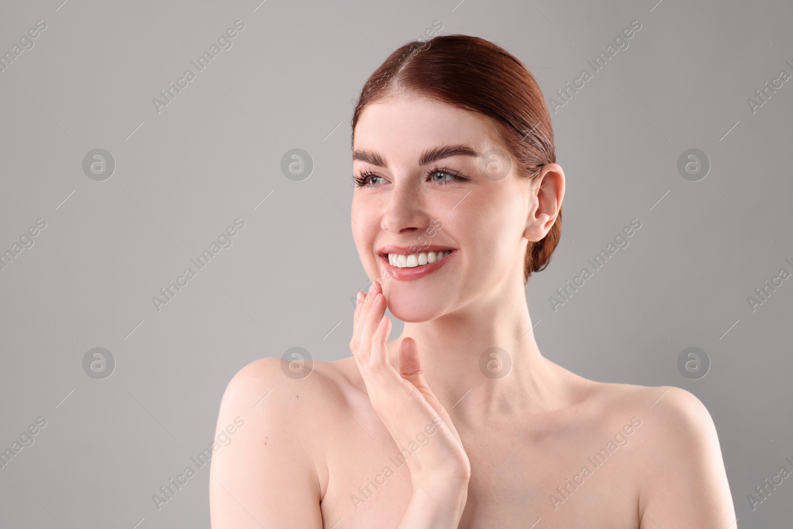 Photo of Portrait of smiling woman on grey background