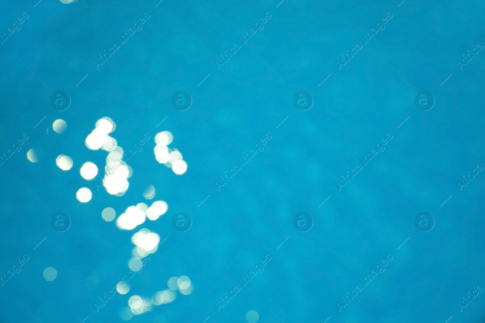 Photo of Surface of swimming pool with clean blue water as background. Bokeh effect