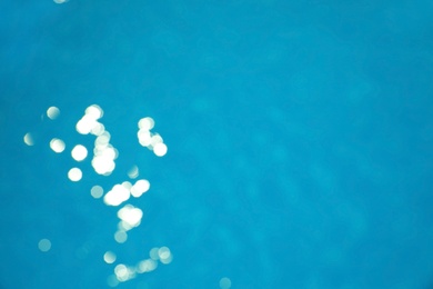 Photo of Surface of swimming pool with clean blue water as background. Bokeh effect