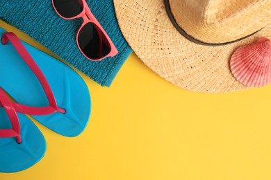 Photo of Flat lay composition with different beach accessories on yellow background. Space for text