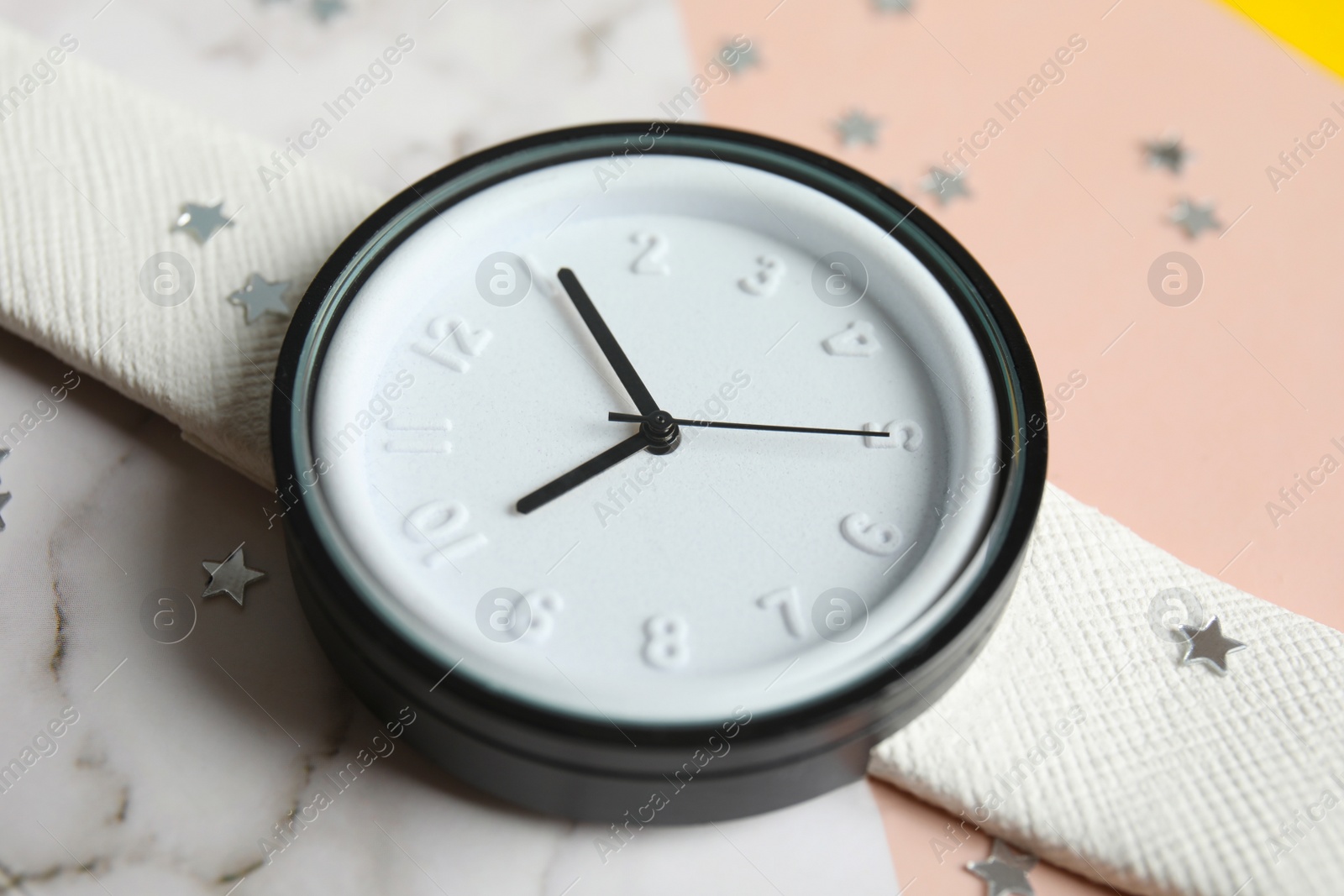 Photo of Stylish wrist watch on marble table, closeup. Fashion accessory