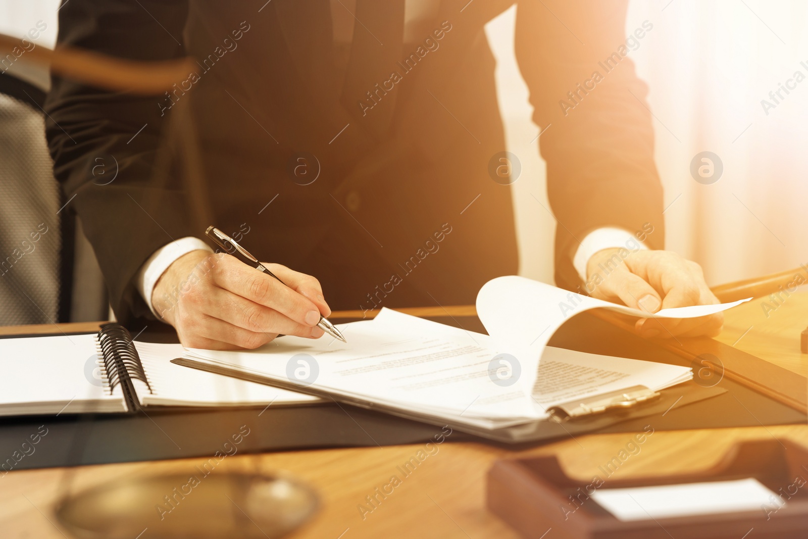 Image of Lawyer working with documents at wooden table in office, closeup