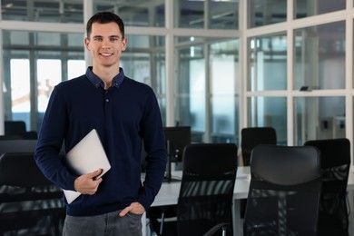 Photo of Happy man with laptop in office, space for text