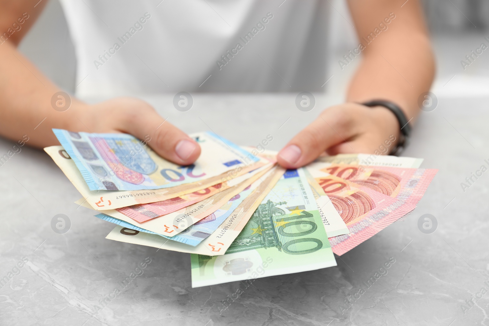 Photo of Man with Euro banknotes at table, closeup