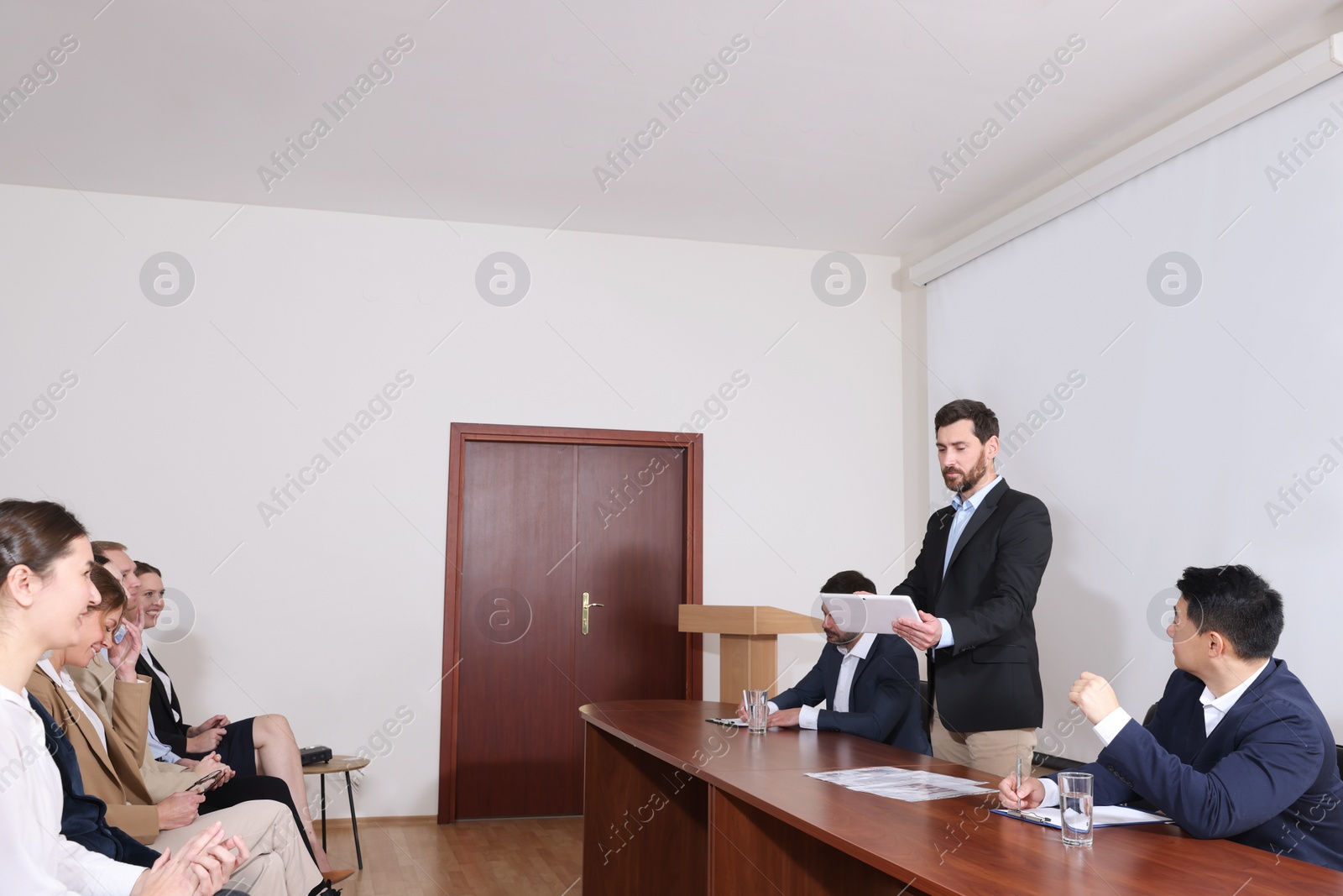 Photo of Business conference. People in meeting room listening to speaker report