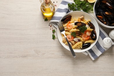 Delicious pasta with sea food served on white wooden table, flat lay. Space for text