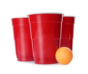 Photo of Red plastic cups and ball for beer pong on white background