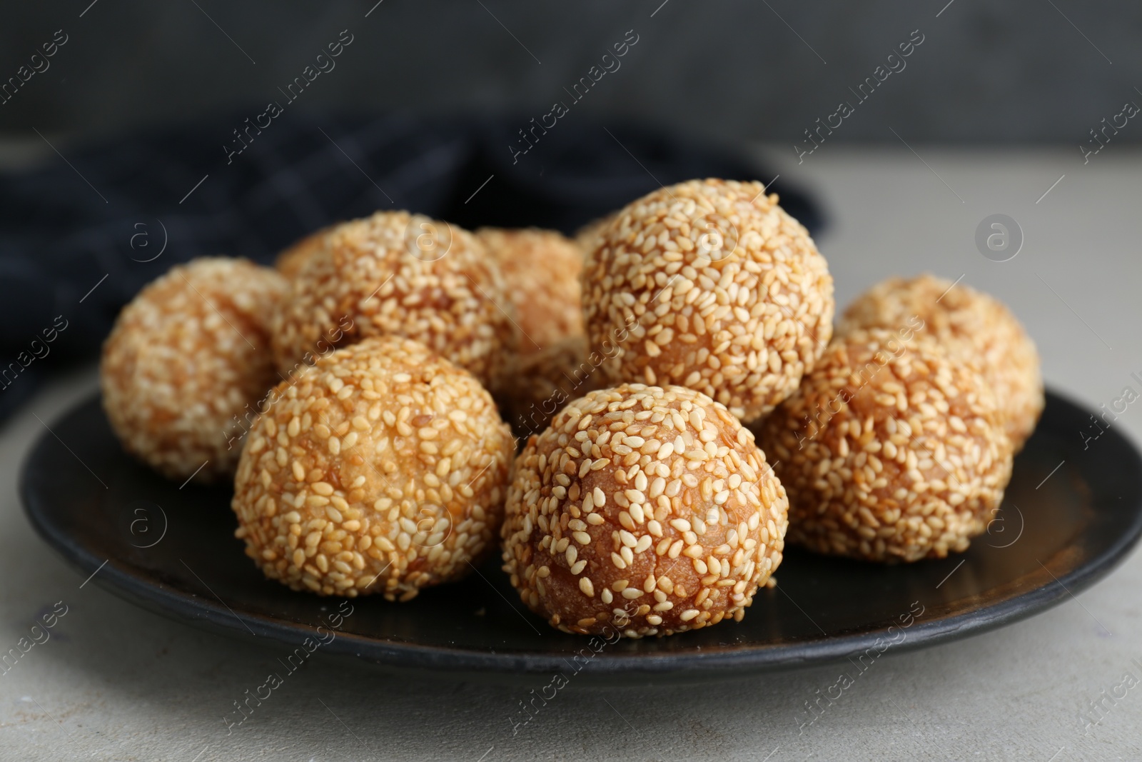 Photo of Delicious sesame balls on light grey table, closeup
