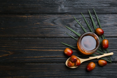 Flat lay composition with palm oil and fresh fruits on wooden table. Space for text