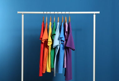 Photo of Bright clothes on blue background. Rainbow colors