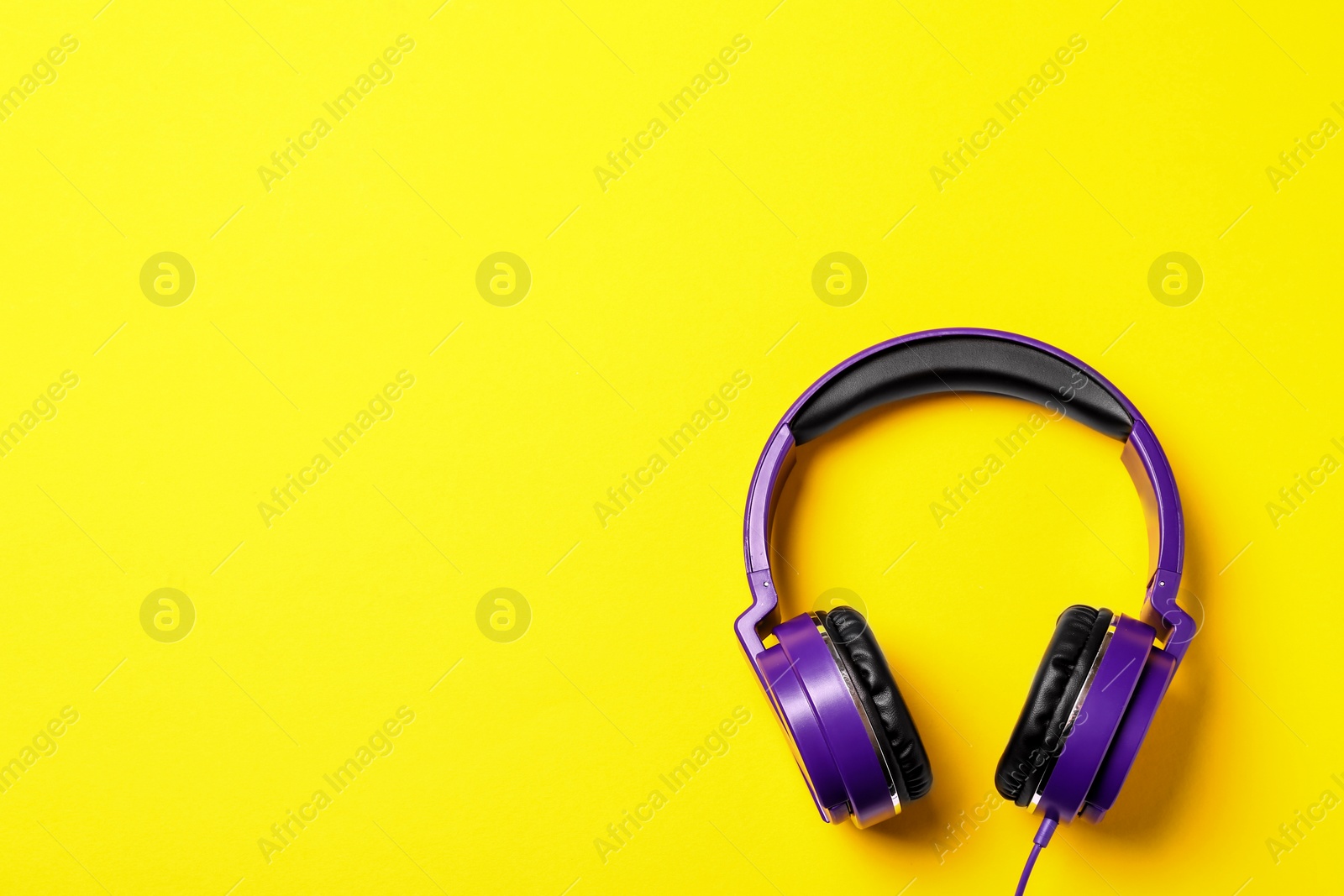 Photo of Stylish modern headphones on color background, top view. Space for text