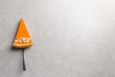 Photo of Piece of fresh delicious homemade pumpkin pie on gray background, top view with space for text