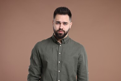 Photo of Portrait of sad man on brown background