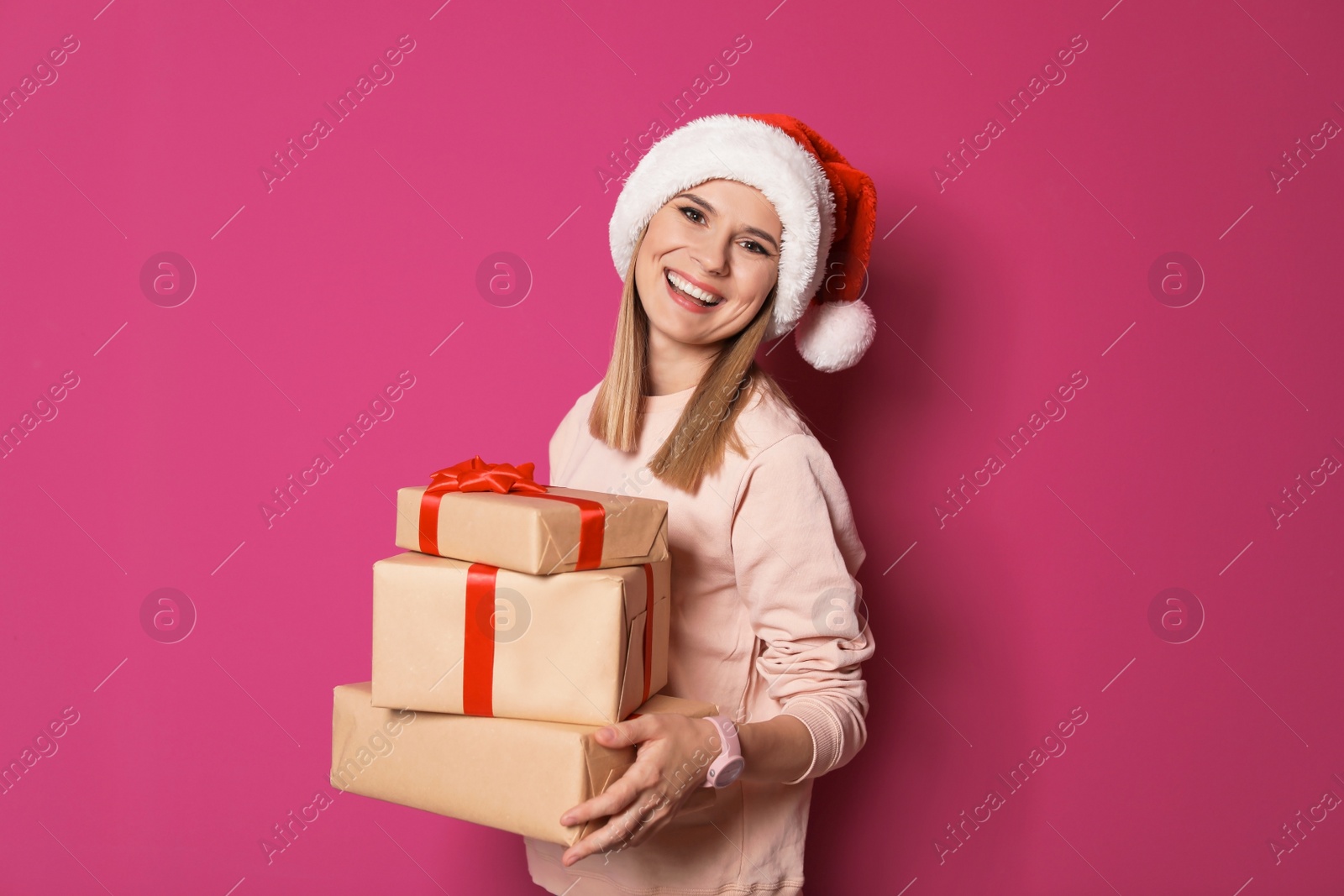 Photo of Young woman with Christmas gifts on color background