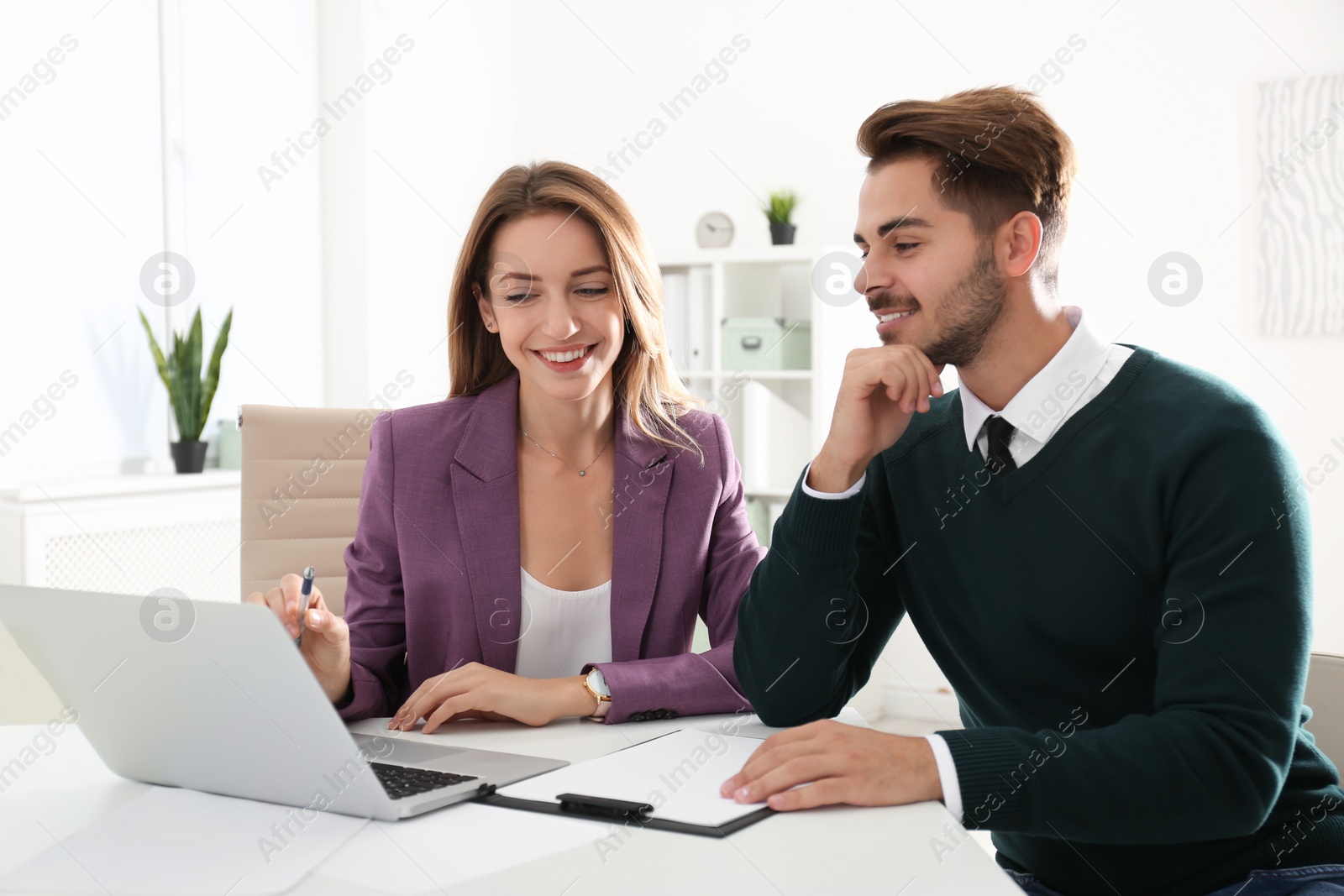 Photo of Real estate agent consulting client in office