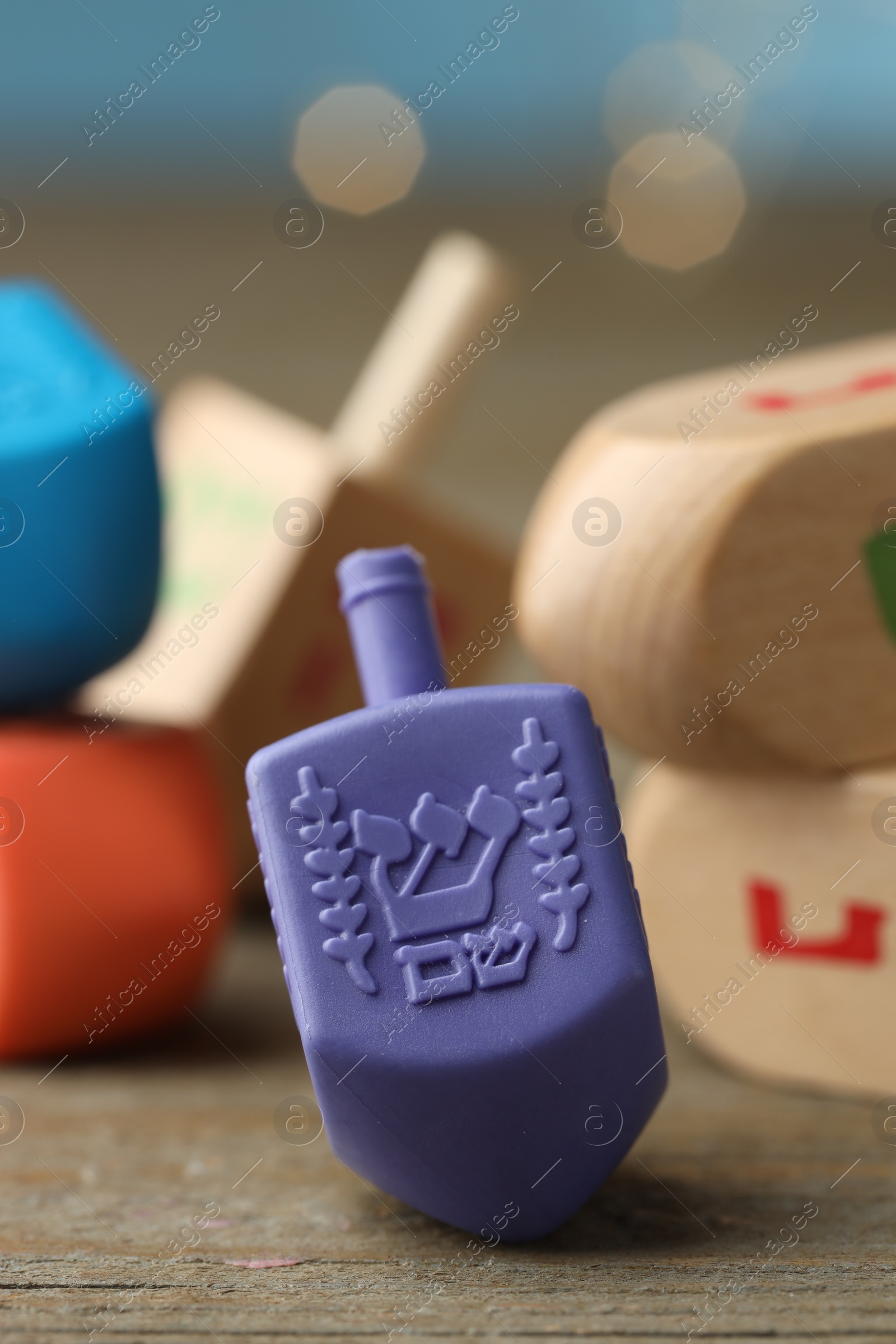 Photo of Hanukkah celebration. Dreidels with jewish letters on wooden table, closeup