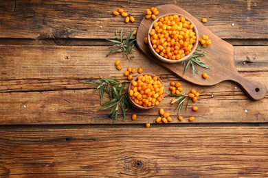 Fresh ripe sea buckthorn on wooden table, flat lay. Space for text