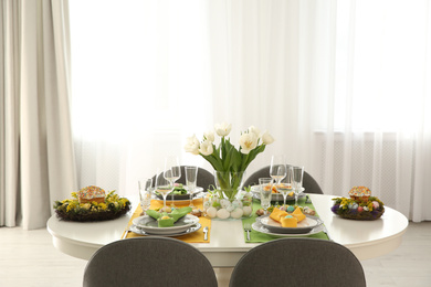Photo of Festive Easter table setting with beautiful white tulips and eggs indoors