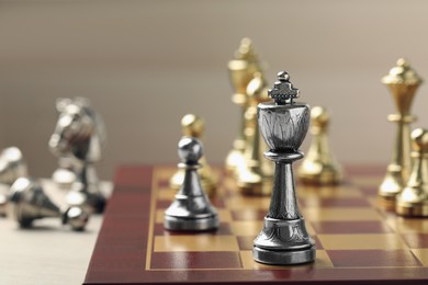 Chessboard with game pieces on beige background, closeup. Space for text