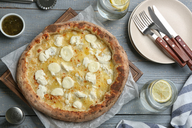 Photo of Tasty cheese pizza served on grey wooden table, flat lay