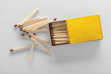 Photo of Cardboard box and matches on white background, top view. Space for design
