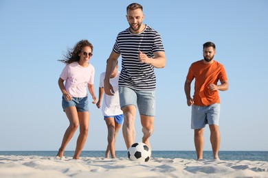 Photo of Group of friends playing football on beach