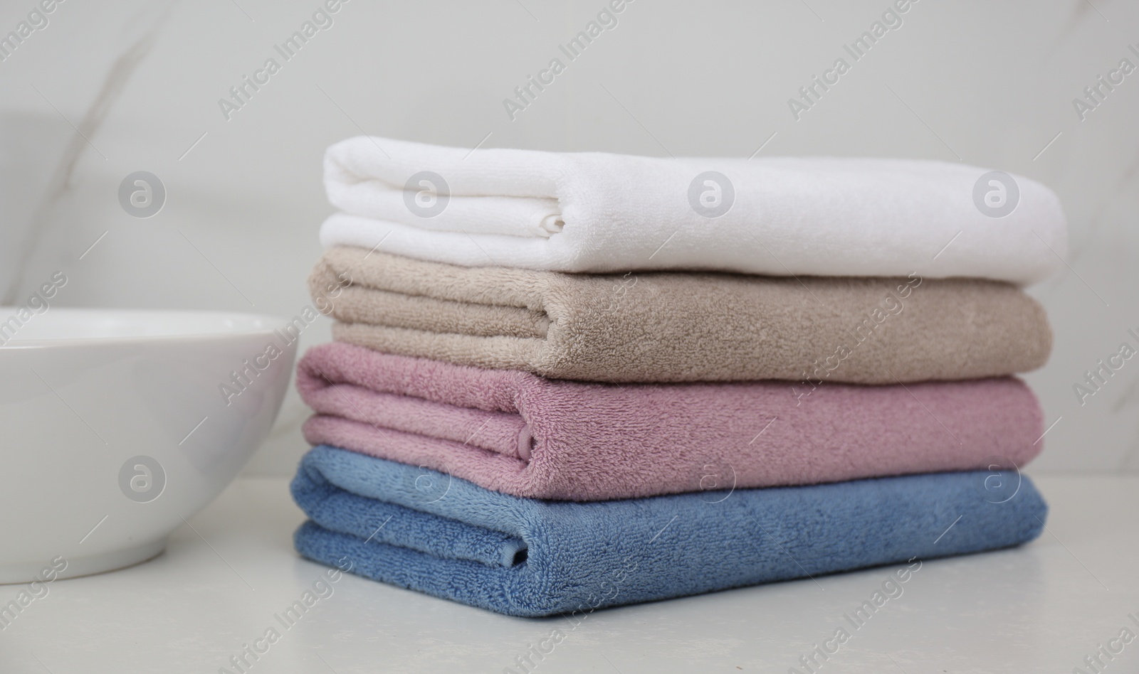 Photo of Stack of fresh towels in bathroom. Laundry day