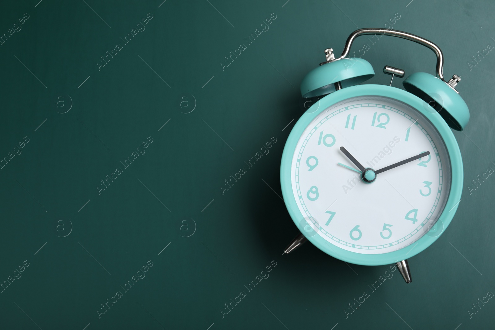 Photo of Alarm clock on green chalkboard, top view with space for text. School time