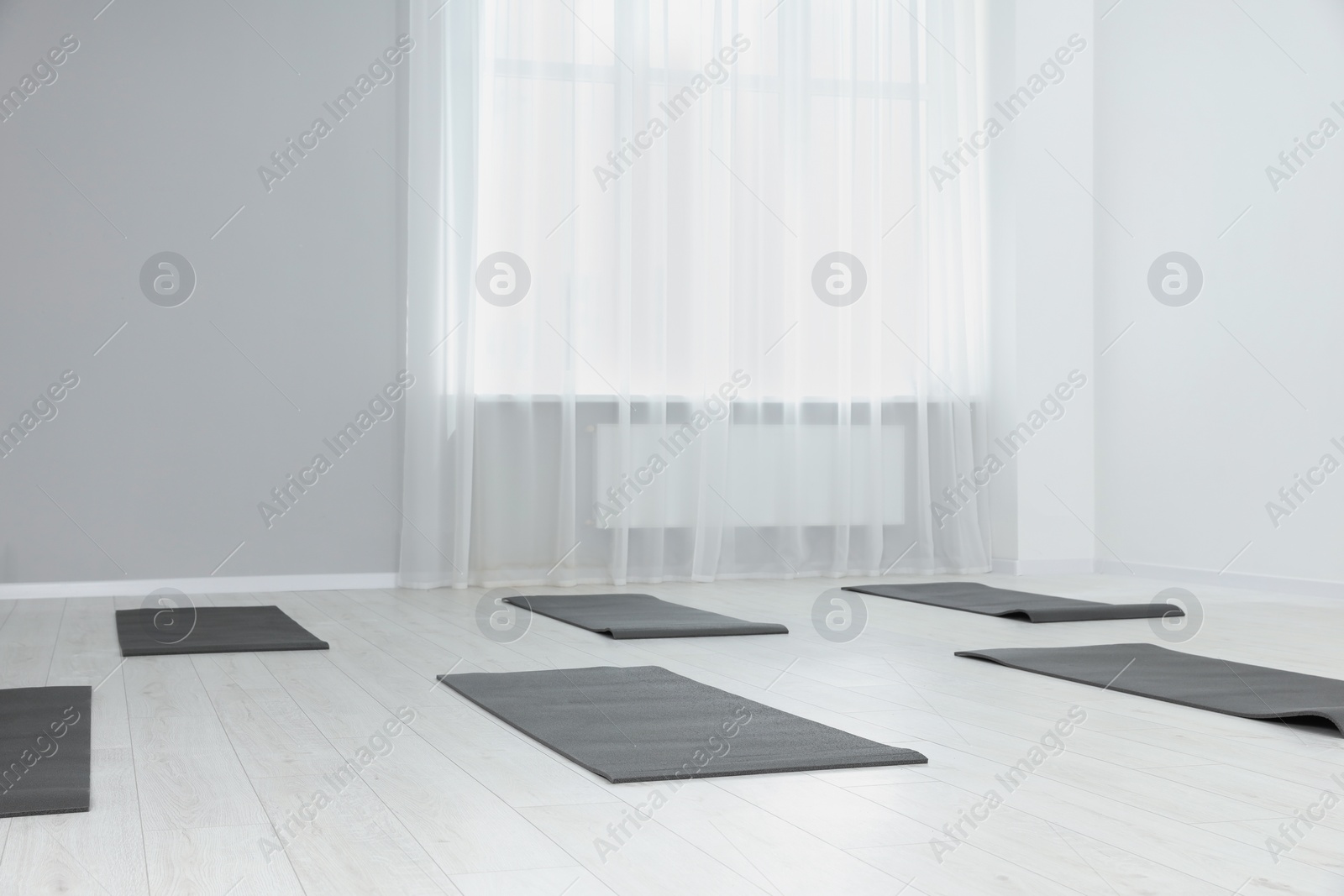 Photo of Spacious yoga studio with exercise mats. Space for text