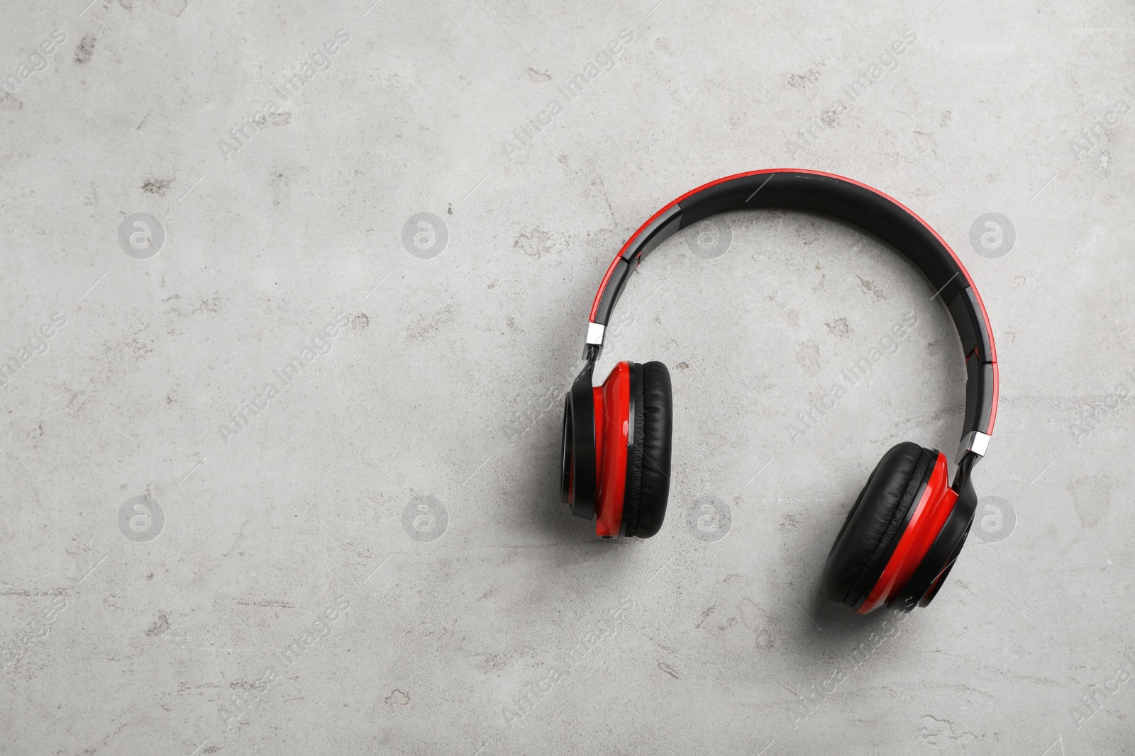 Photo of Stylish modern headphones and space for text on gray background, top view