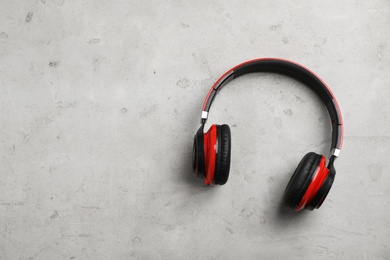 Stylish modern headphones and space for text on gray background, top view